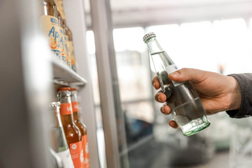 Hand nimmt Getränk aus Kühlschrank