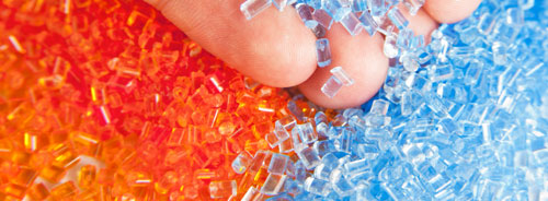 Zu Kunststoffverarbeitung, Kunststoffgranulat in Fingern