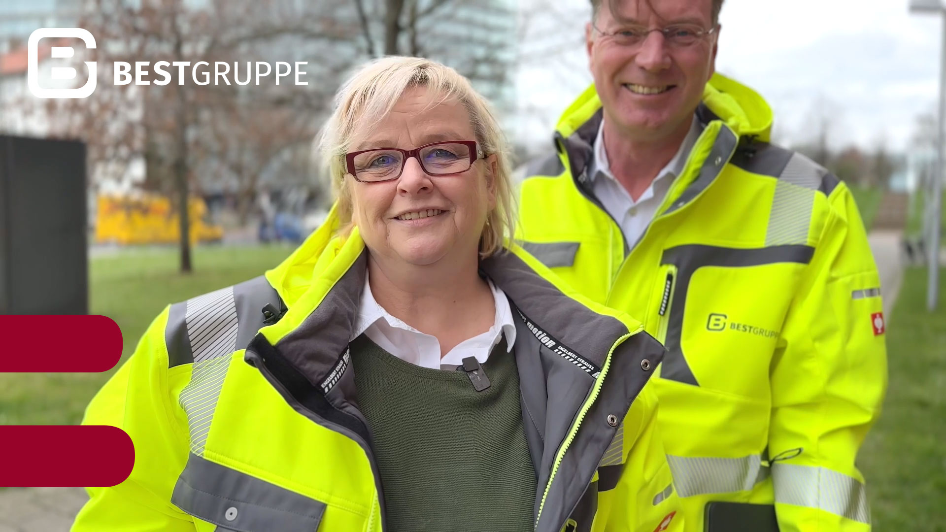 Mitarbeiterin Heike Eckloff und Geschäftsführer Stefan Peters in Signal-Warnschutzjacken lächeln in die Kamera
