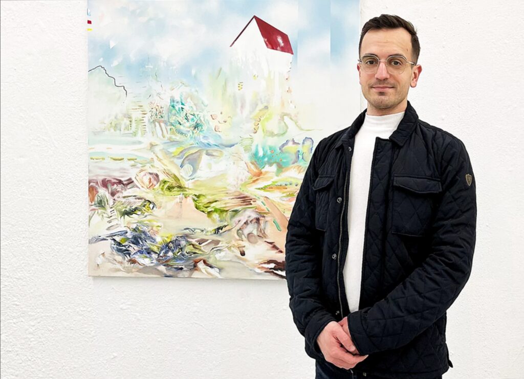 Alex Fedmann vor einem seiner Bilder an der Wand.