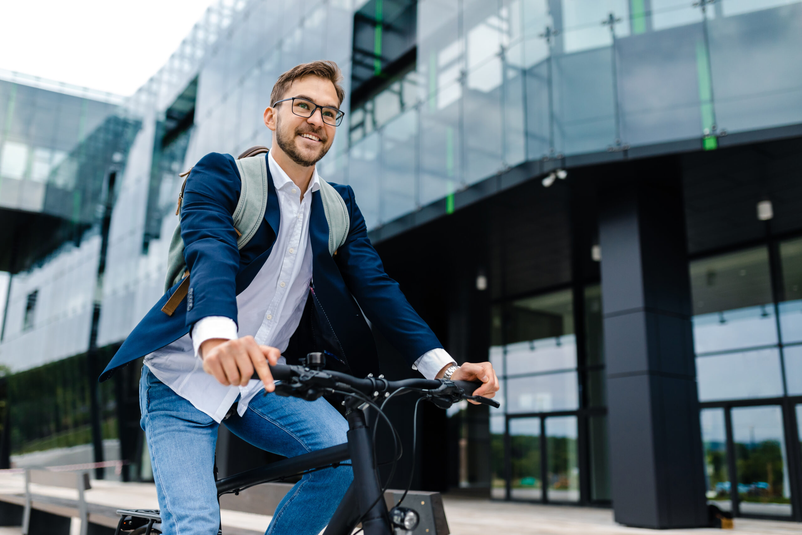 Junger glücklicher Mann fährt mit seinem Fahrrad zur Arbeit.
