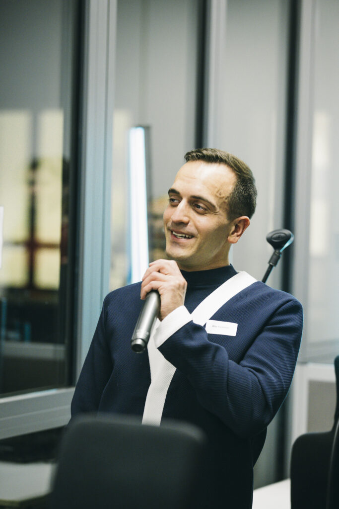 Künstler Alex Fedmann spricht ins Mikrofon.