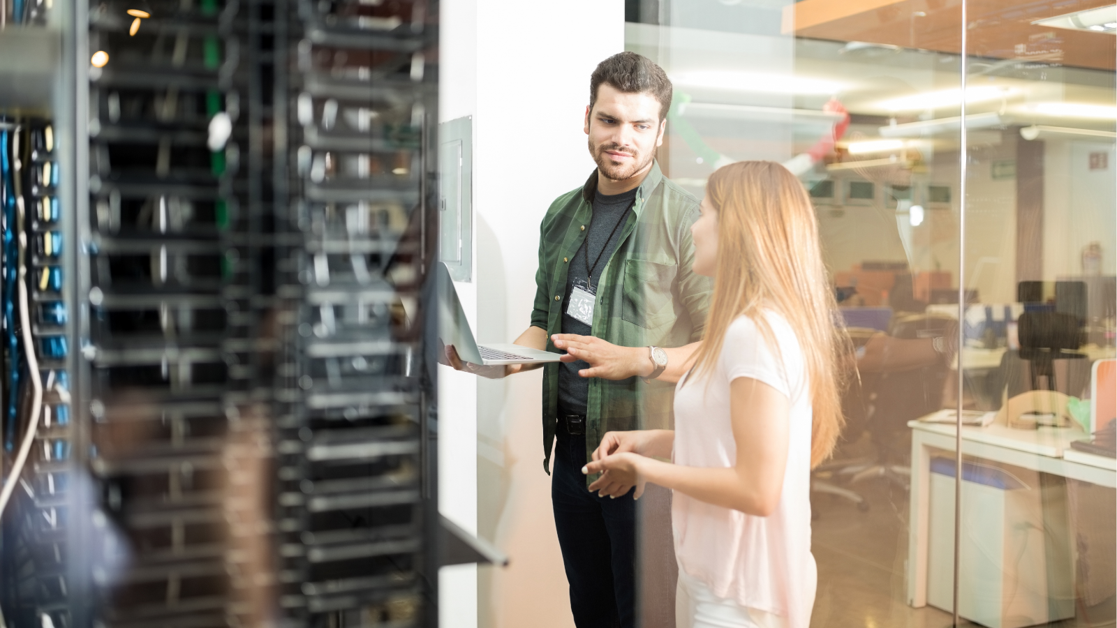 Ein Mann und eine Frau stehen vor dem Serverraum im Unternehmen