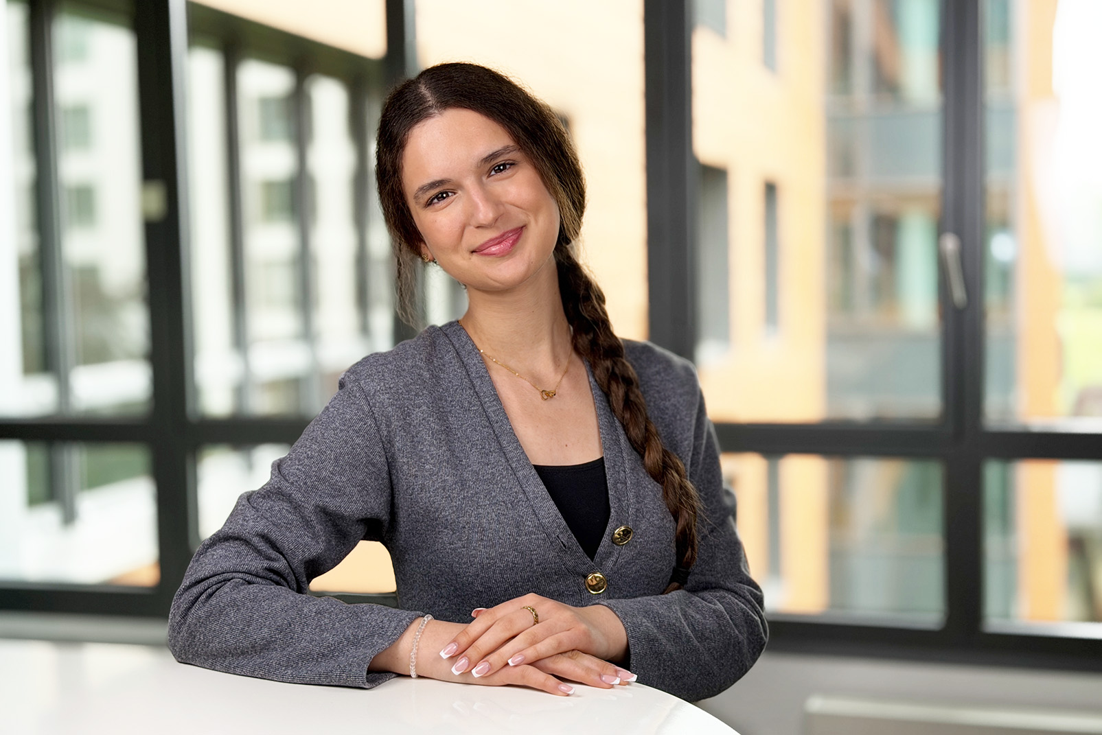 Jovana steht lächelnd an einem hohen Tisch